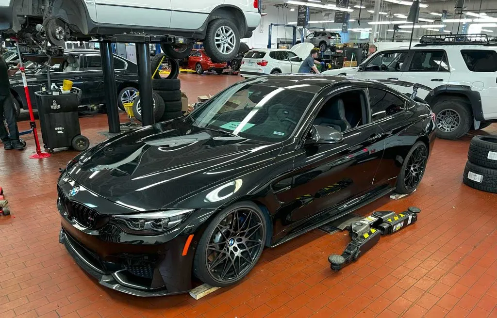 black f82 bmw m4 getting H&R lowering springs installed at bmw dealership